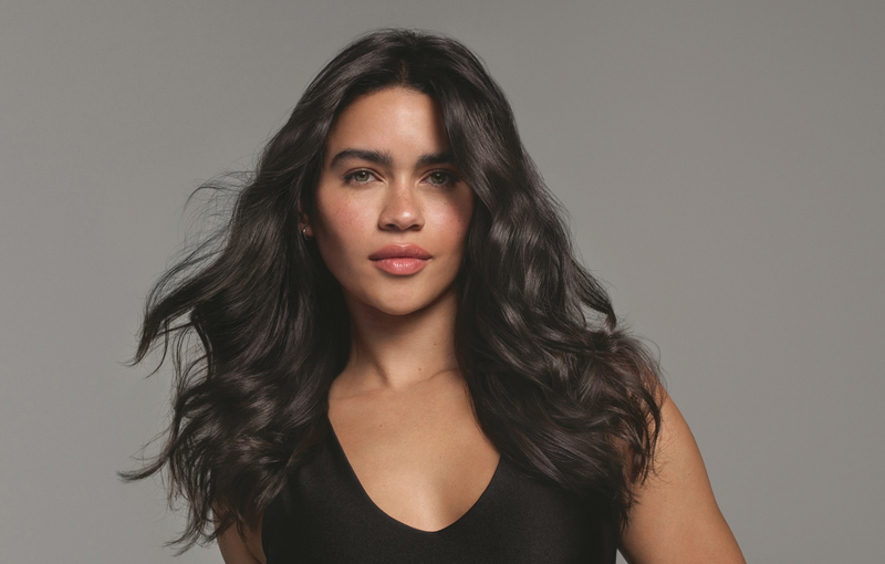 Female with long brunette hair styled using Alterna haircare