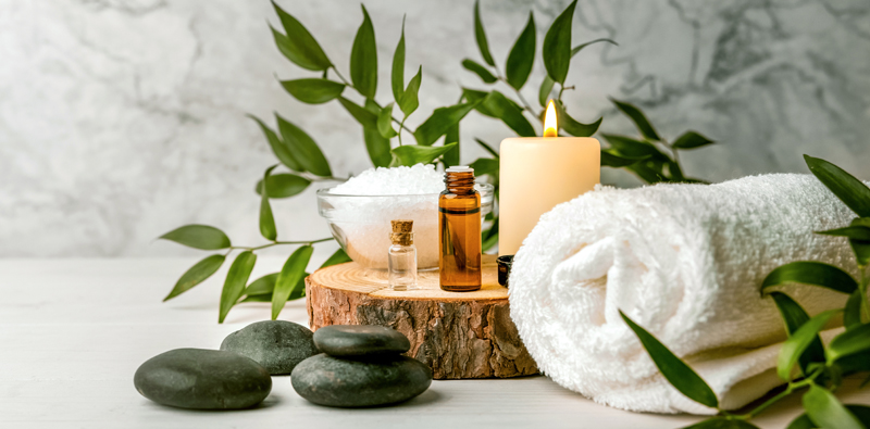 Facial products alongside a candal and a towel