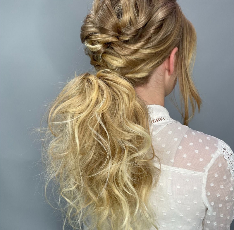 A woman with her hair styled in a ponytail for a wedding day