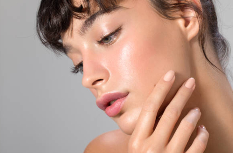 Close up of a womans face with her nails on her cheek