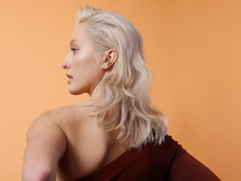 Woman with blonde hair styled by using evo haircare products