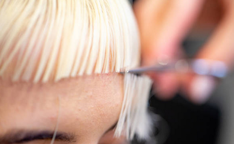 Close up of a woman having her fringe cut
