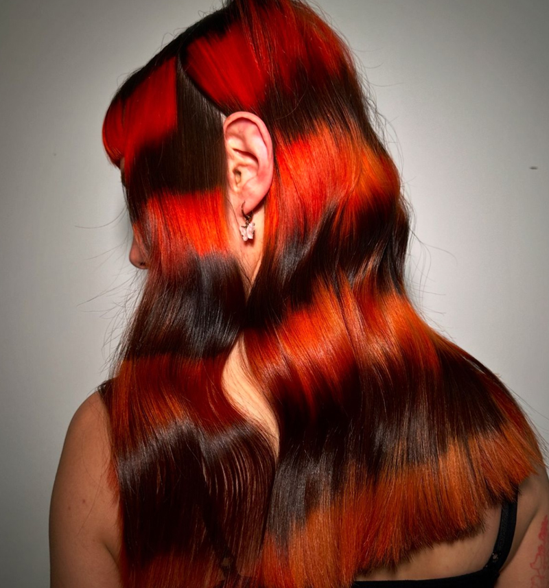 A woman with hair coloured in a black and red striped pattern