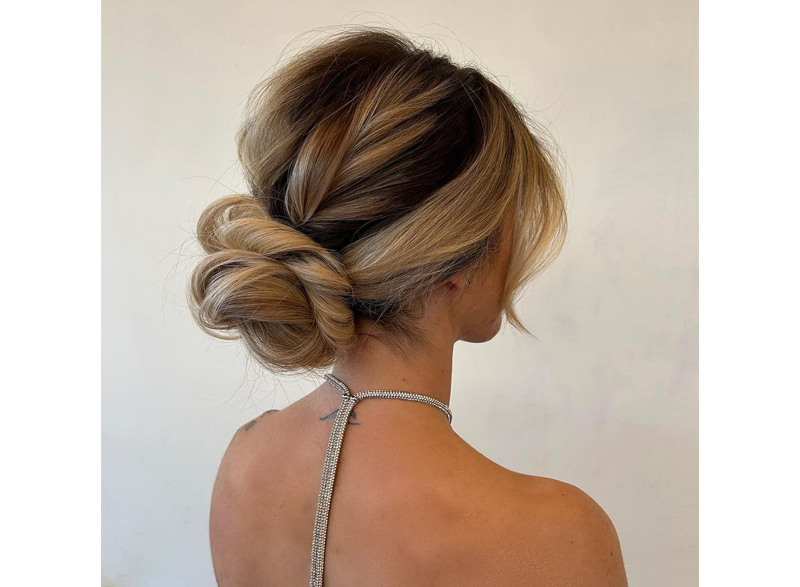 Woman with her hair styled in a low messy bun