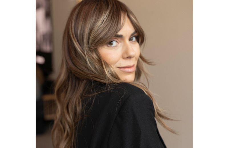 A woman with long wavy brunette hair