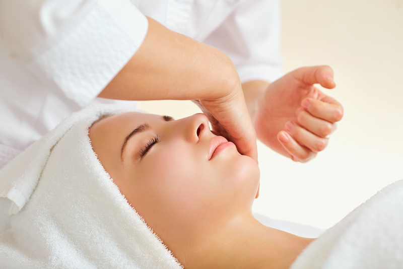 A woman receiving a facial from a therapist