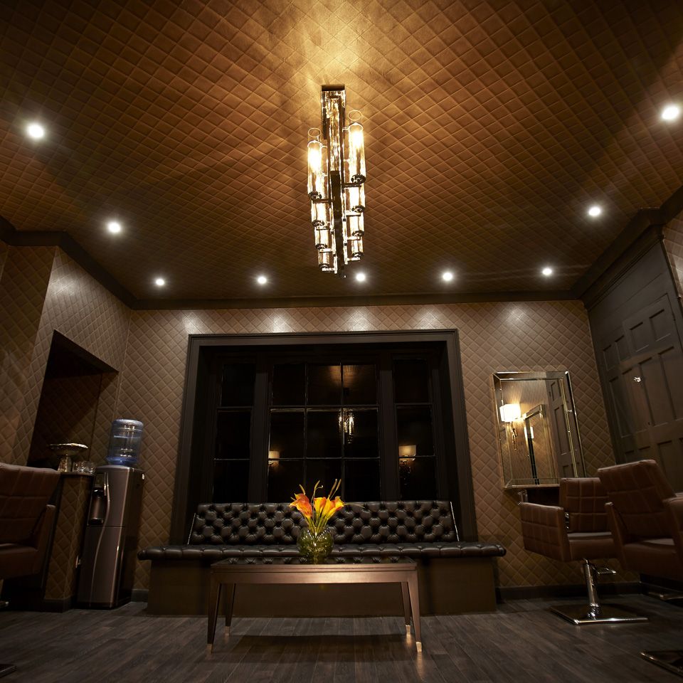 Reception area with a large leather, buttoned sofa and a table with orange and yellow lilies