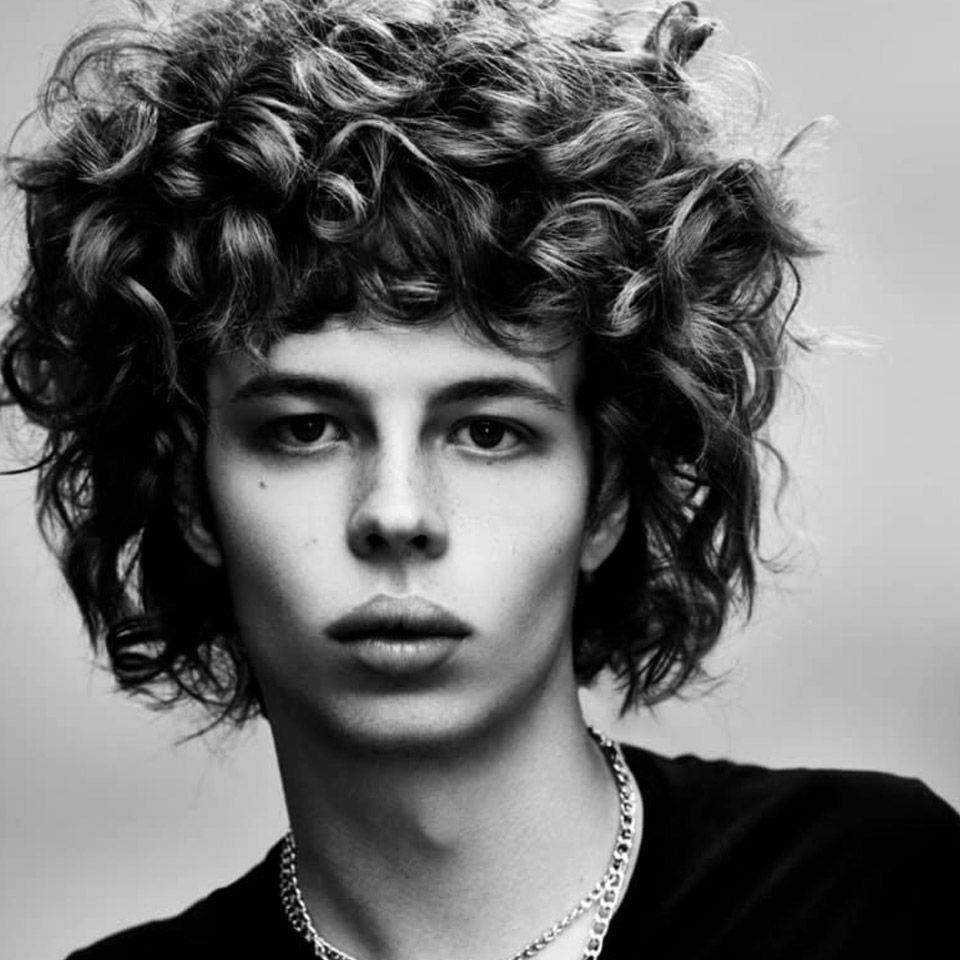 Black and white image of a man with curly hair created by Ego Hair Design