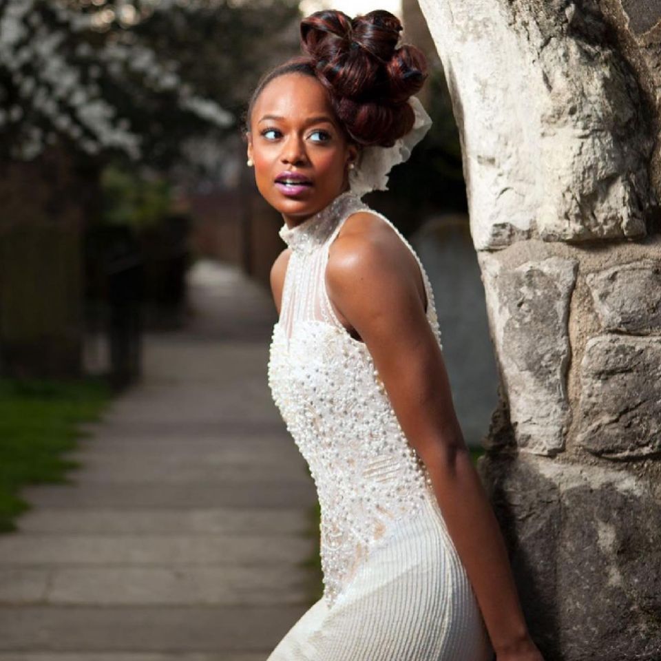A model wearing a wedding dress with knotted hair-up