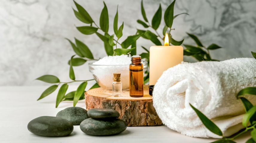 Facial products alongside a candal and a towel