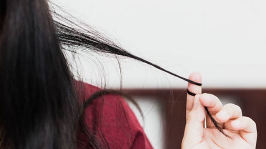 Close up image of a woman pulling and twisting her hair