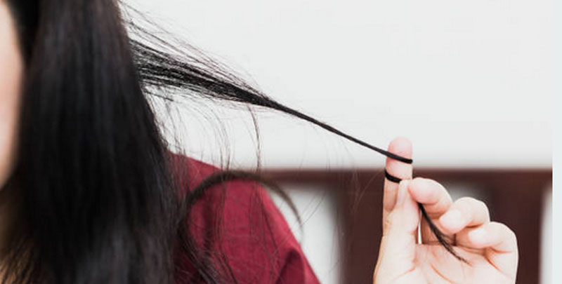 Close up image of a woman pulling and twisting her hair